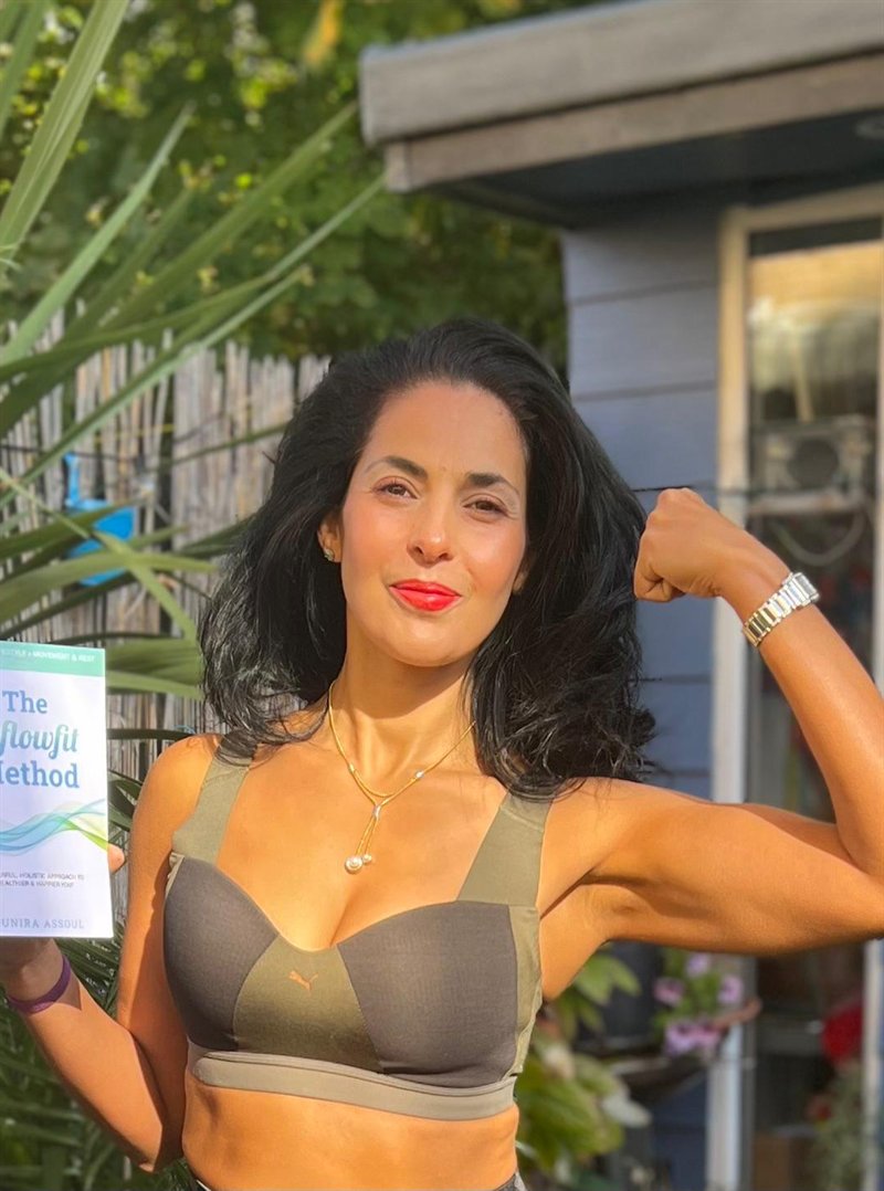 Mounira Assoul holding her book, The Inflowfit Method